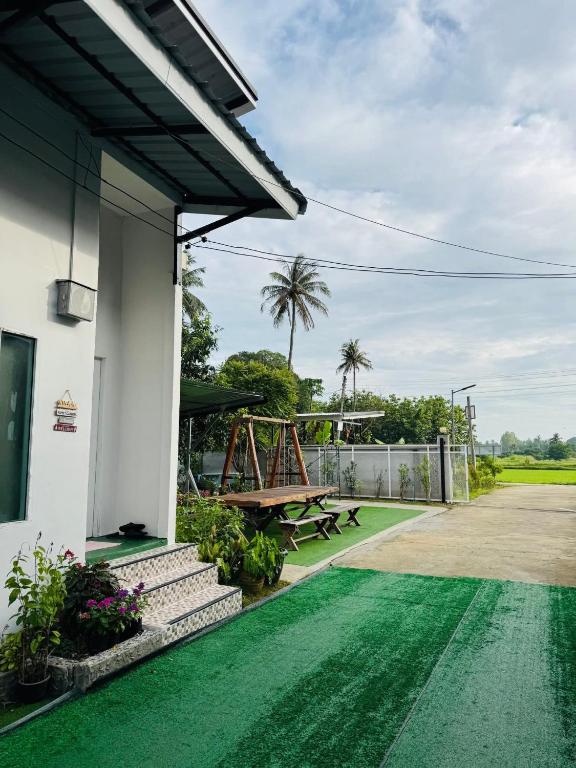 a house with a green floor and a picnic table at เจเจรีสอร์ท in Ban Mo