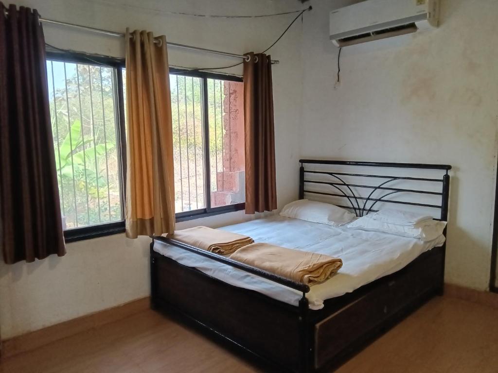 a bed in a room with a large window at Golden Oriole Homestay in Srīvardhan