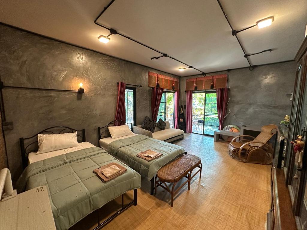a bedroom with two beds and a couch at Ban Buarawong บ้านบัวระวงค์ in Ban Nong Faek