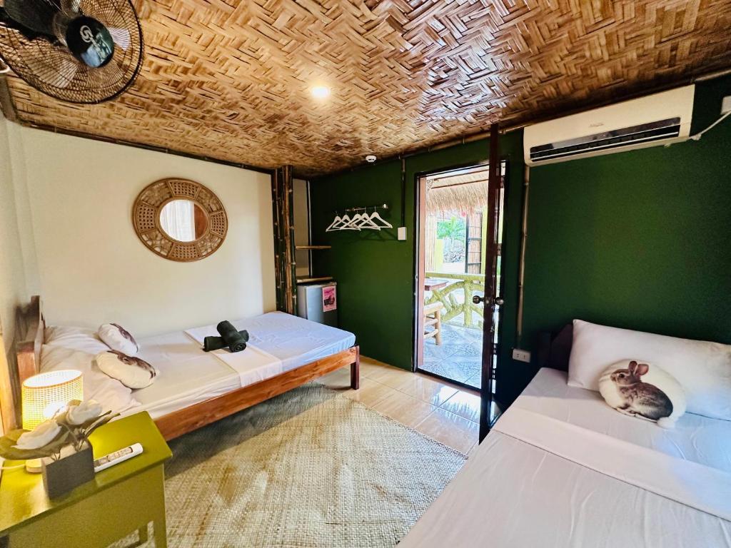 a room with two beds and a green wall at The Green House Port Barton in San Vicente