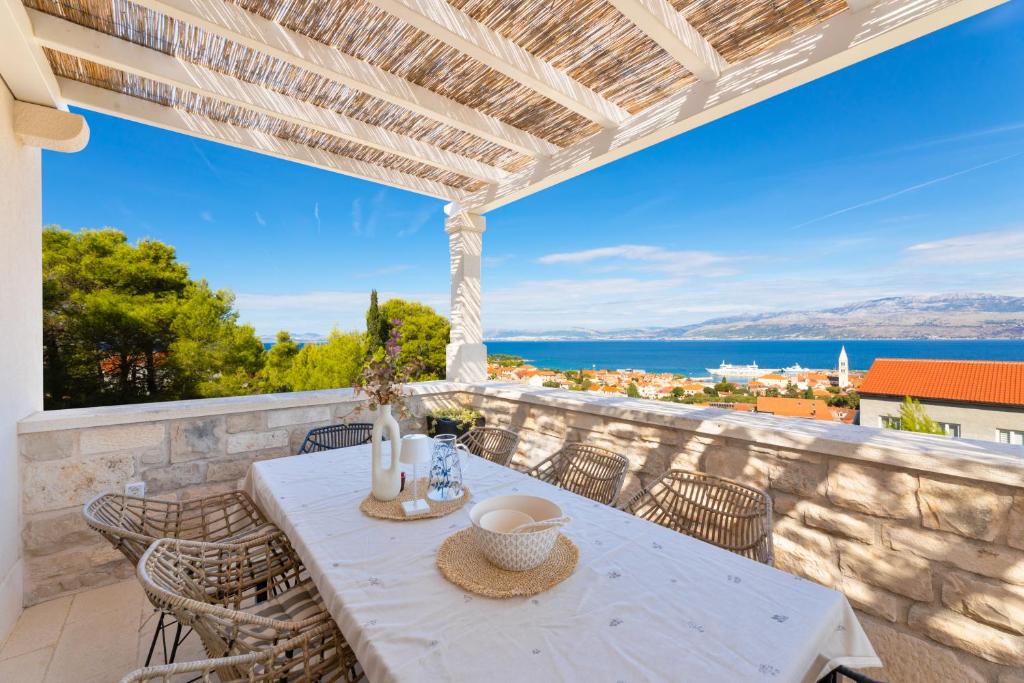 a table on a balcony with a view of the ocean at Villa Aries in Supetar