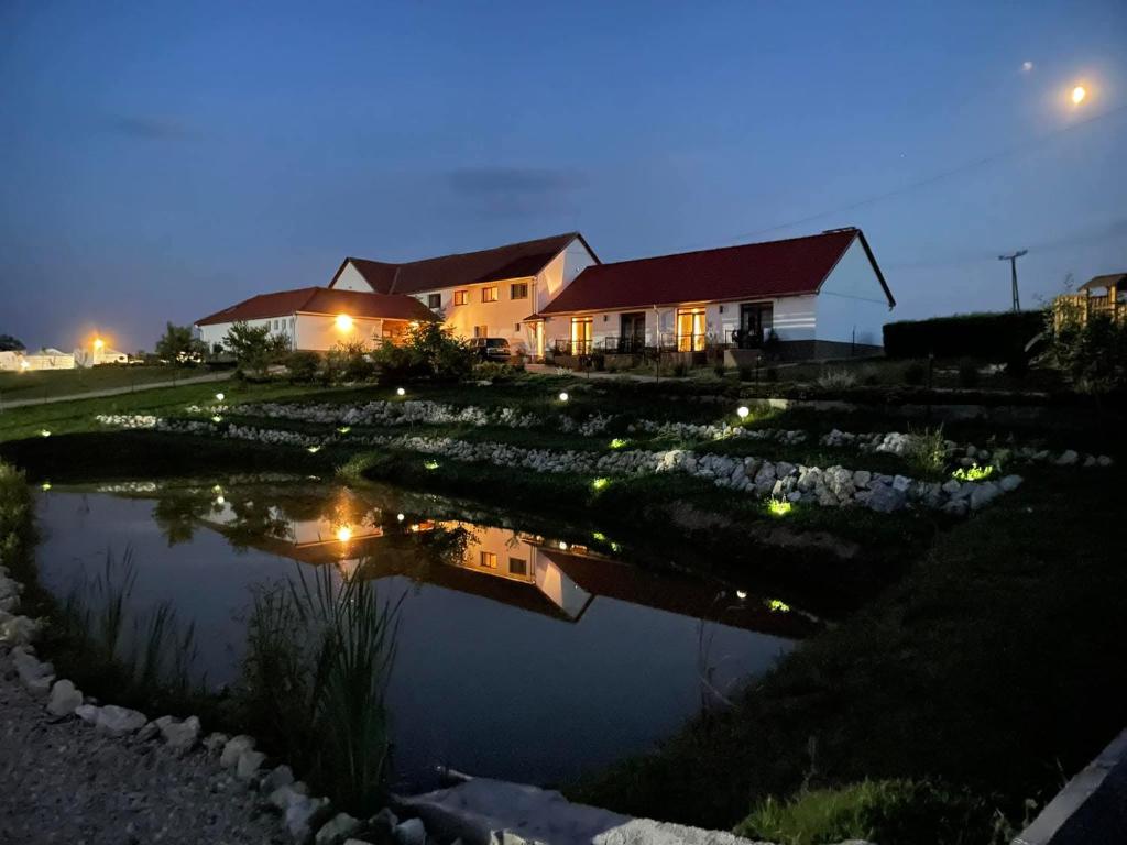una casa con luci in acqua di notte di Alsószuhai Dűlő Vendégház És Rendezvényterem a Alsószuha