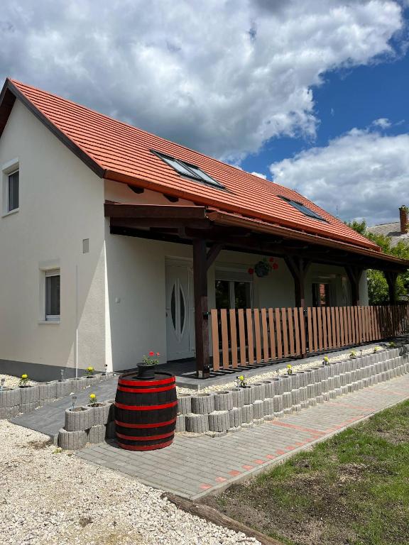 a white house with a red roof and a porch at Jolcsi Apartman in Balatonfüred