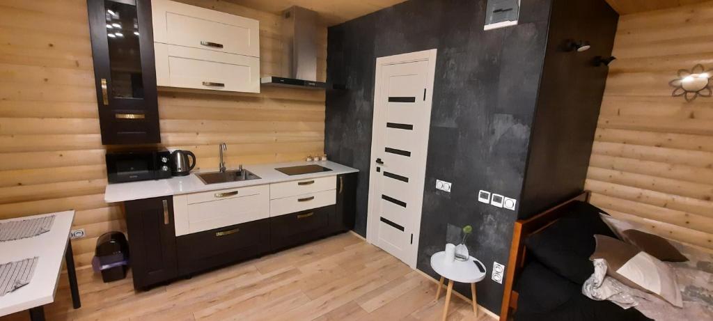 a kitchen with white cabinets and a black wall at Gastehaus in Kostyantynivka