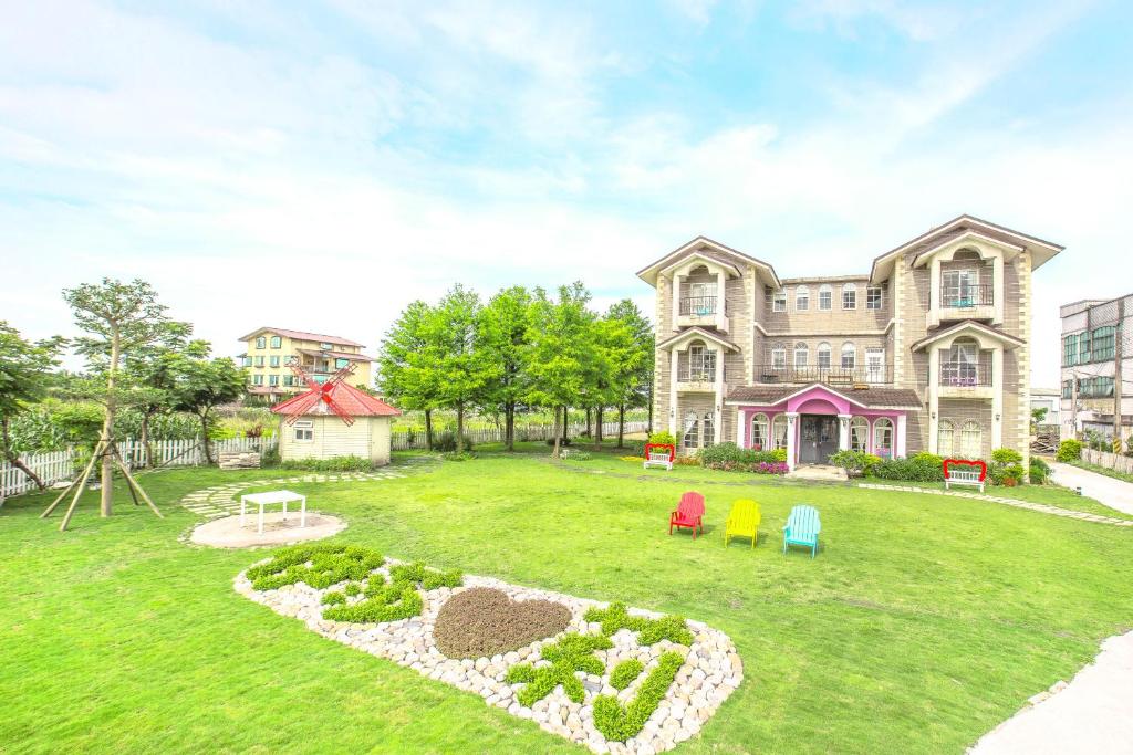 a large house with a yard with a playground at 伊莎愛莉溜滑梯親子民宿 in Wujie