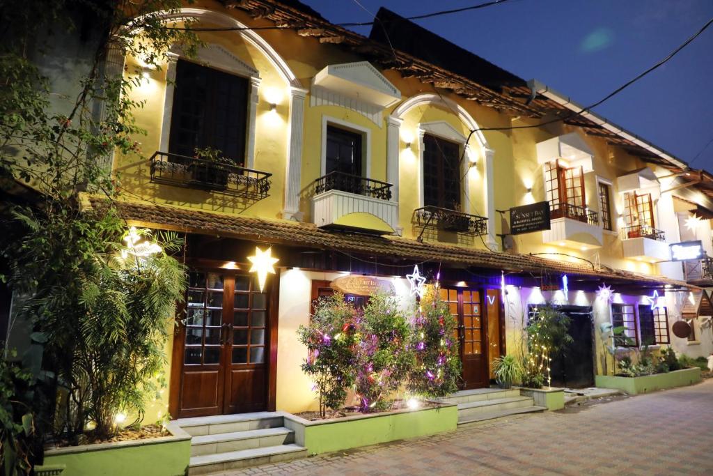 un edificio con dei fiori di fronte ad esso di notte di THE SUNSET BAY a Fort Kochi