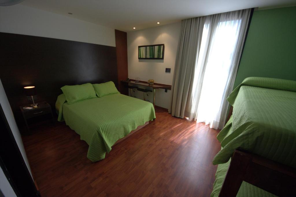 a hotel room with two beds and a window at Sur Hotel in Montevideo