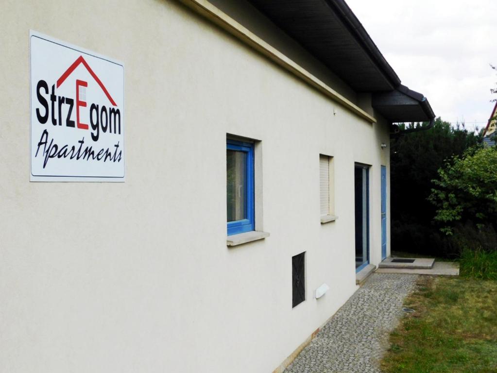 a white building with a sign on the side of it at Strzegom Apartament-Pokoje in Strzegom