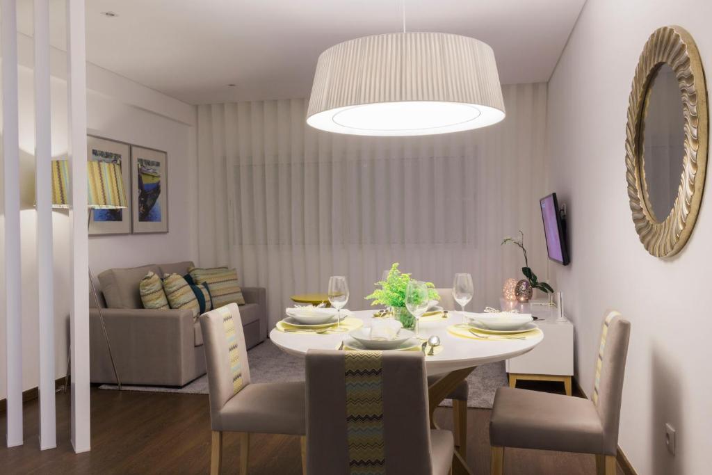comedor con mesa y sillas blancas y comedor en Bracara Guest House "Arco", en Braga