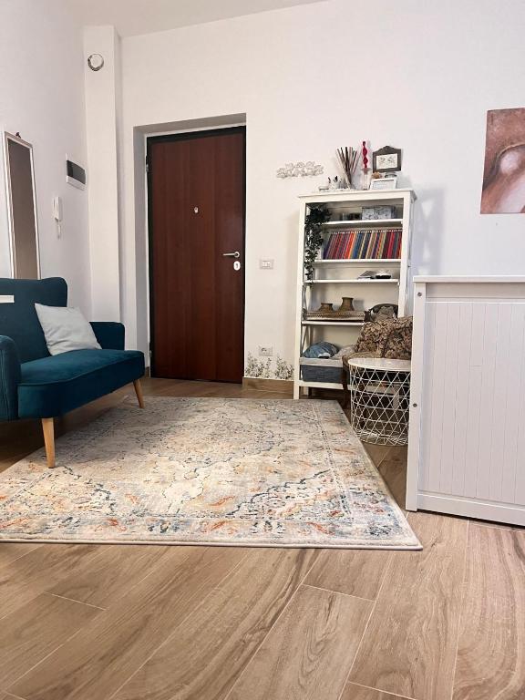 a living room with a blue chair and a door at Monolocale Corbetta centro - House lab Milan in Corbetta