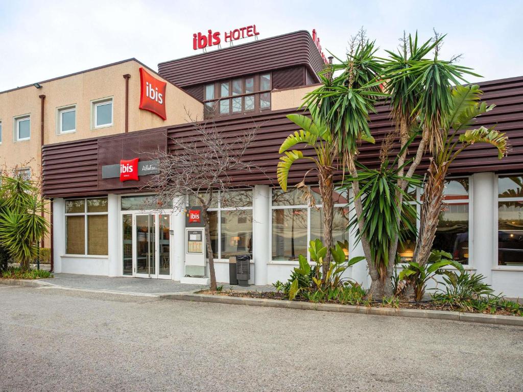 un negozio con palme di fronte di Ibis Valencia Alfafar ad Alfafar