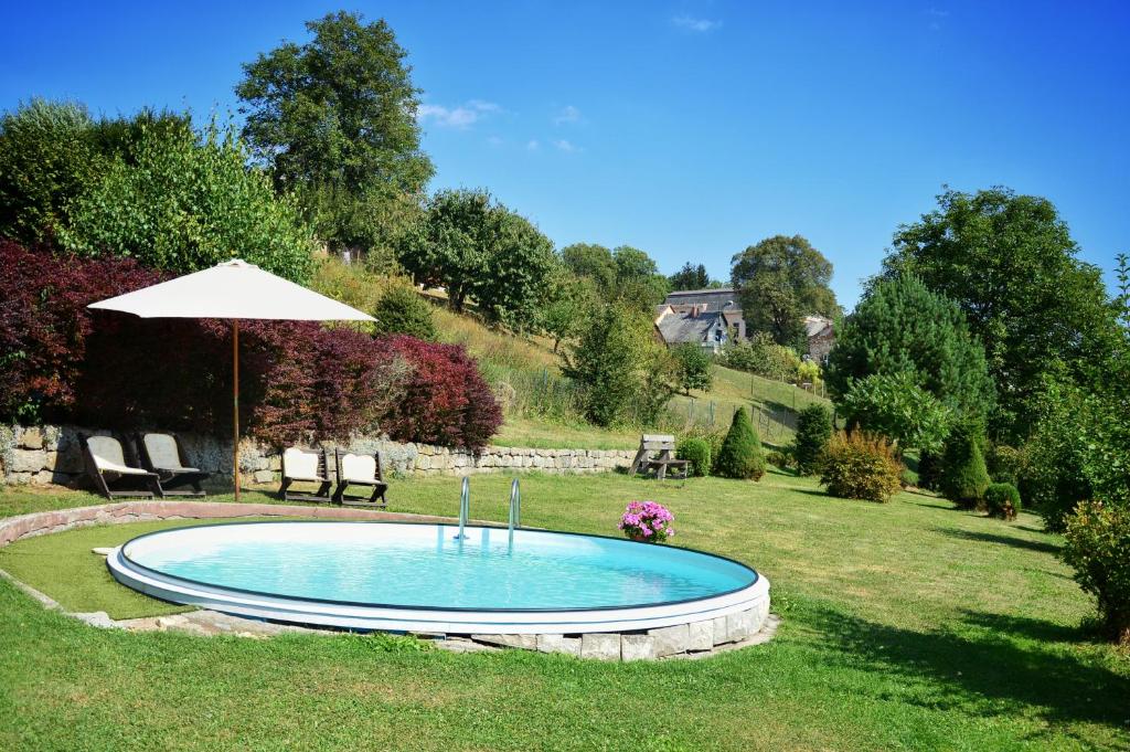 una pequeña piscina en un patio con sombrilla en Guest House Kuks, en Kuks