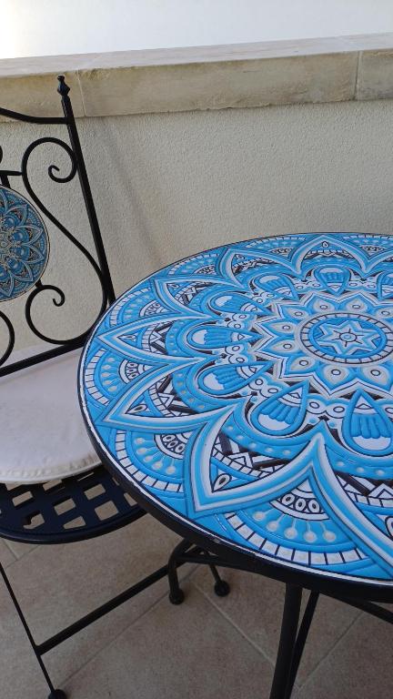een tafel met een blauw bord op een stoel bij Casa PERLAMARE in Otranto
