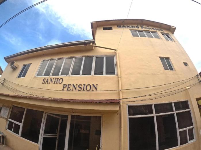 a tan building with a santa sabina passion at Coron Sanho Pension in Coron