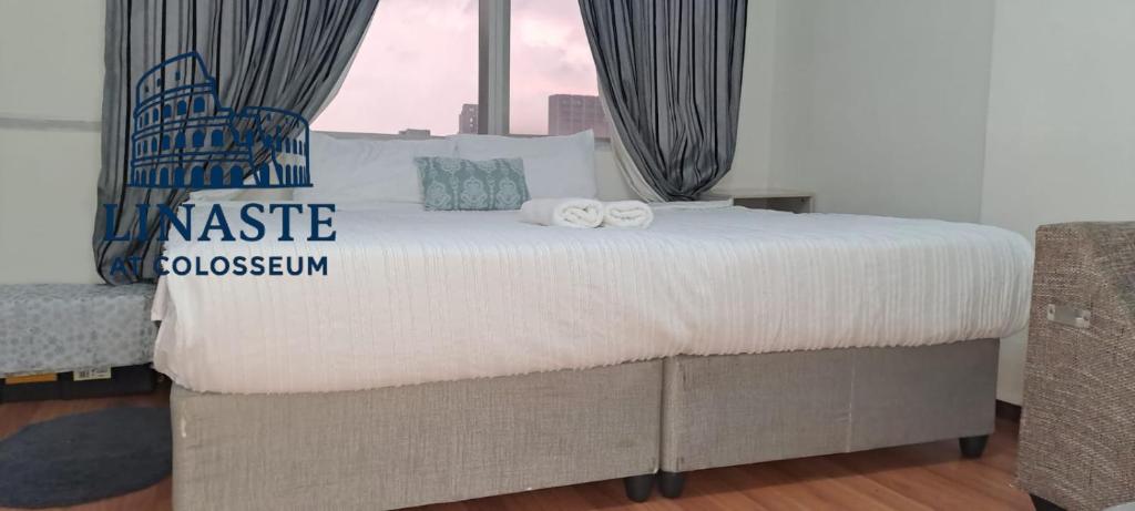 een groot bed met twee handdoeken erop bij Linaste at Colosseum in Johannesburg