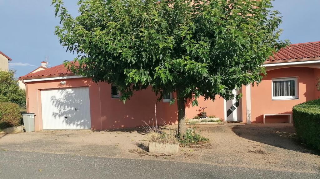 a garage with a tree in front of a house at Mafadel in Cluny