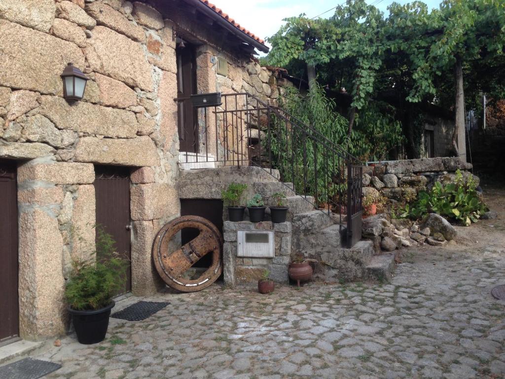 Entre Ambos os Rios的住宿－Cantinho Redondo Gerês，一座石头建筑,有植物,有砖院