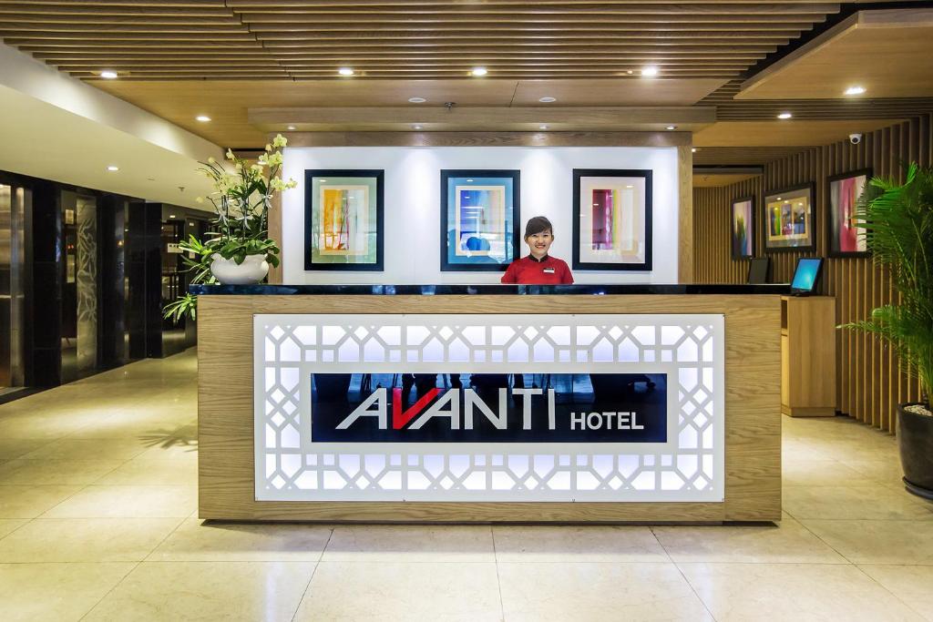 a person standing behind a counter in a hotel lobby at Avanti Hotel in Ho Chi Minh City
