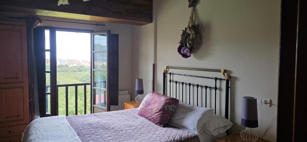 una camera da letto con un letto e una grande finestra di Complejo Rural Las Mimosas del Nalon a San Juan de la Arena