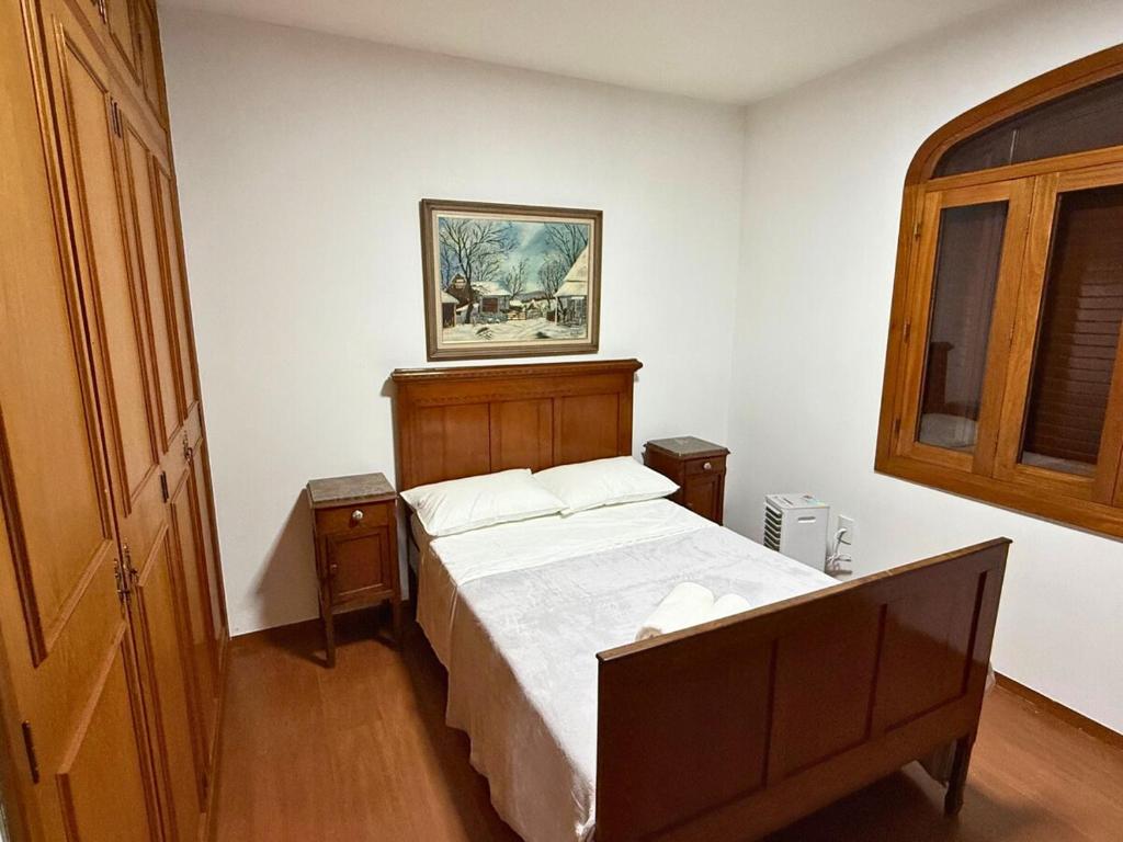 a bedroom with a bed and a picture on the wall at Villa Ipe in Patos de Minas