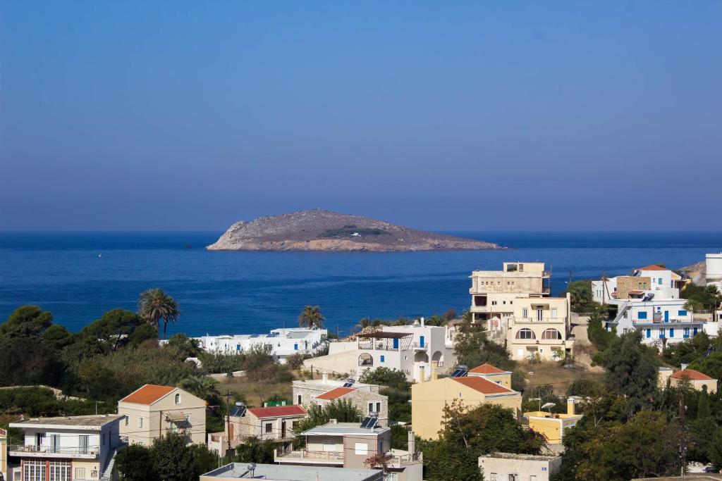 um grupo de casas brancas numa colina junto ao oceano em Studios by Climbing House em Panormos Kalymnos