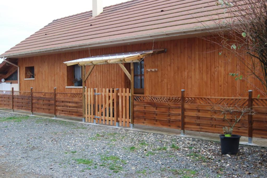 a wooden house with a fence in front of it at Gîte A l'orée des bois in Saint-Robert