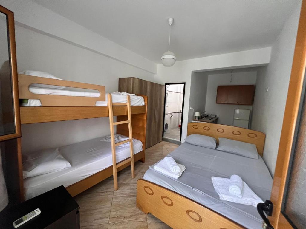 een kleine kamer met 2 stapelbedden en een keuken bij a perfect room in Borsh