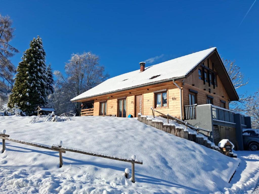 a log cabin in the snow with a fence at le familial avec spa, sauna salle de jeux in Xonrupt-Longemer