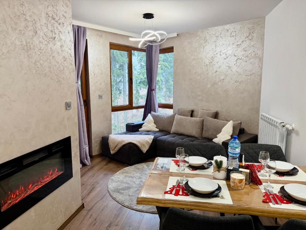 a living room with a table and a couch at Dream Apart - Iceberg in Pamporovo