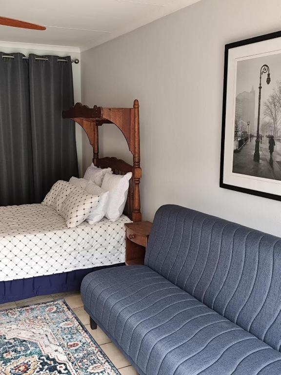 a bedroom with a bed and a couch and a picture at 899 On Burlington in Pretoria