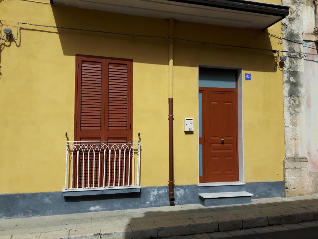パキーノにあるCasa Francescoの赤い扉が2つある黄色い建物