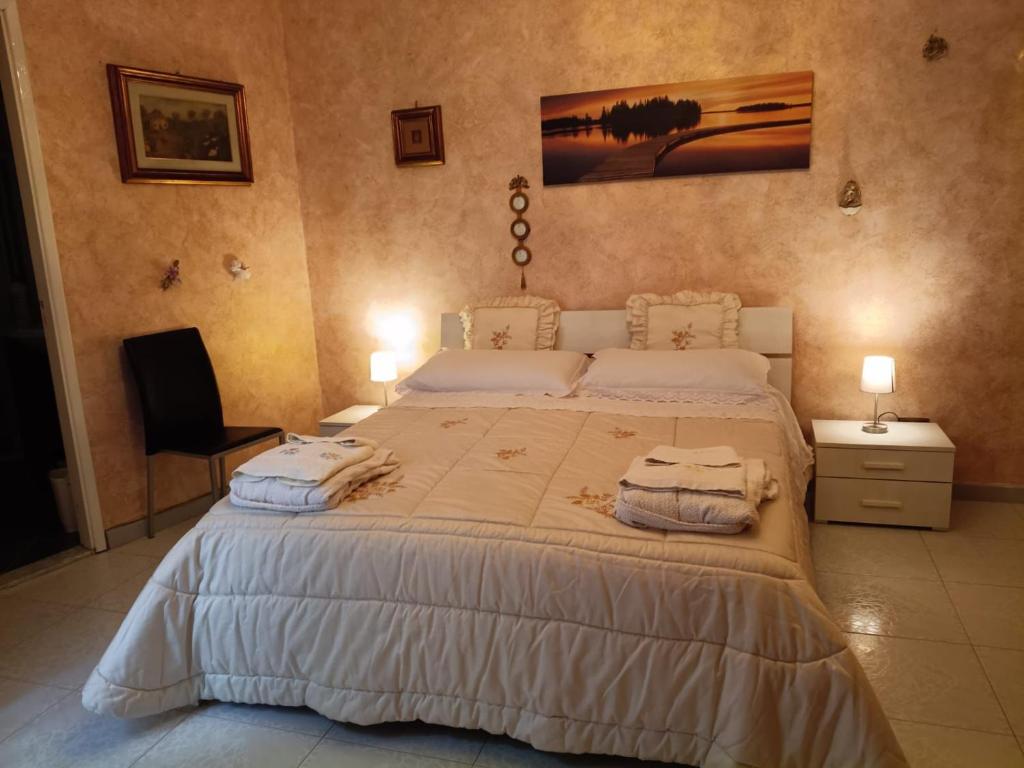 una camera da letto con un letto grande con asciugamani sopra di Appartamento centro storico quartiere San Michele a Sciacca