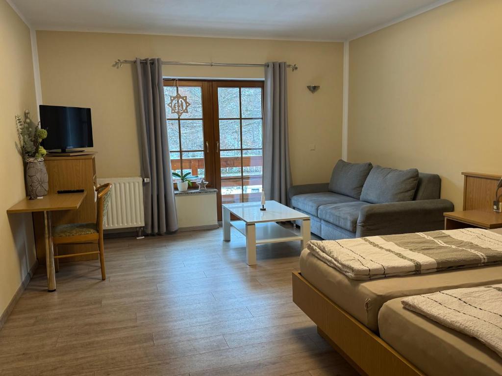 a living room with a couch and a living room with at Pension Ostrauer Mühle in Bad Schandau