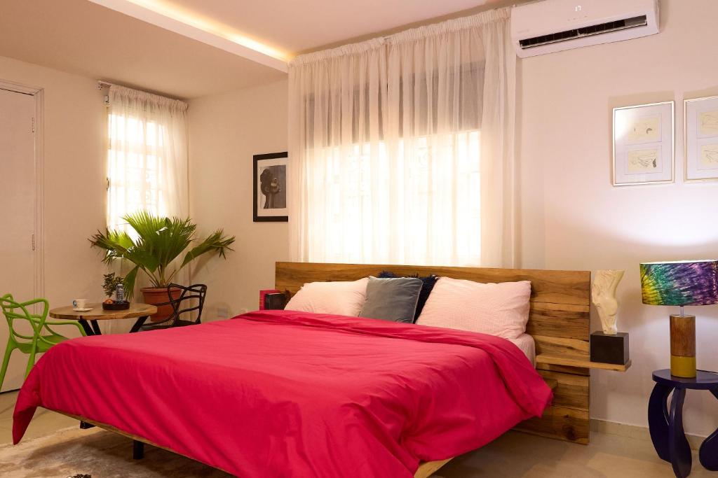 a bedroom with a large bed with a red blanket at Serenity Room, Design House in Lagos