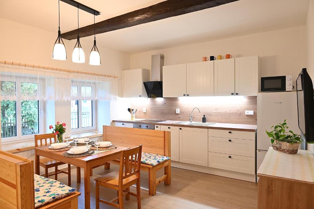 a kitchen with a table and a dining room at Chalupa U lípy in Horní Bělá