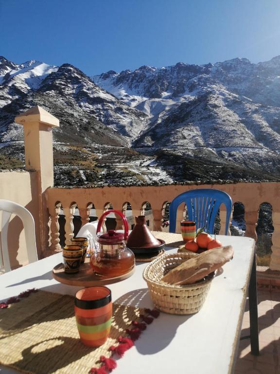 a table with a view of a snow covered mountain at Dar Angour Tacheddirt in Tacheddirt