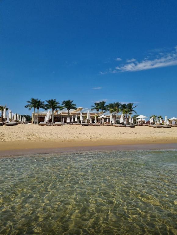 a beach with a group of umbrellas and the water at Apartments complex Breeze Sunny beach - Апартаменти комплекс Бриз Слънчев бряг in Sunny Beach