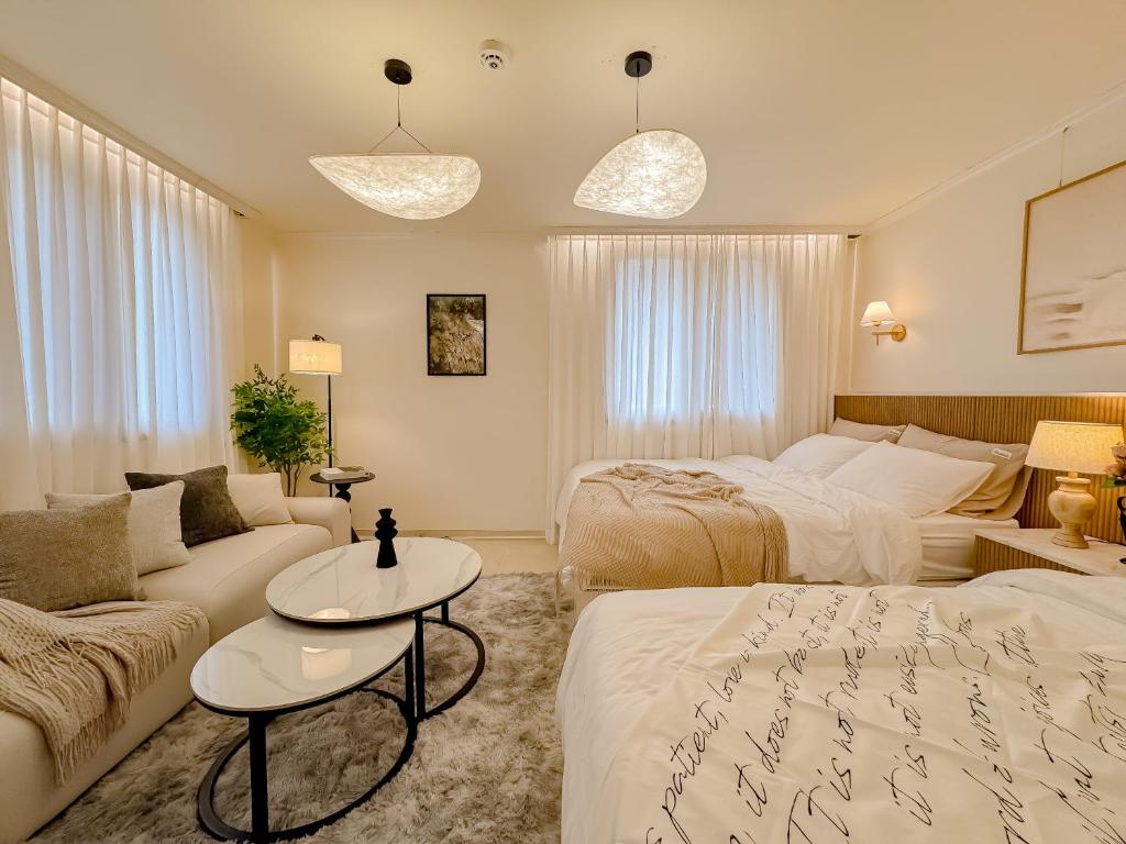 a hotel room with two beds and a couch at 스테이 느릿 in Seoul