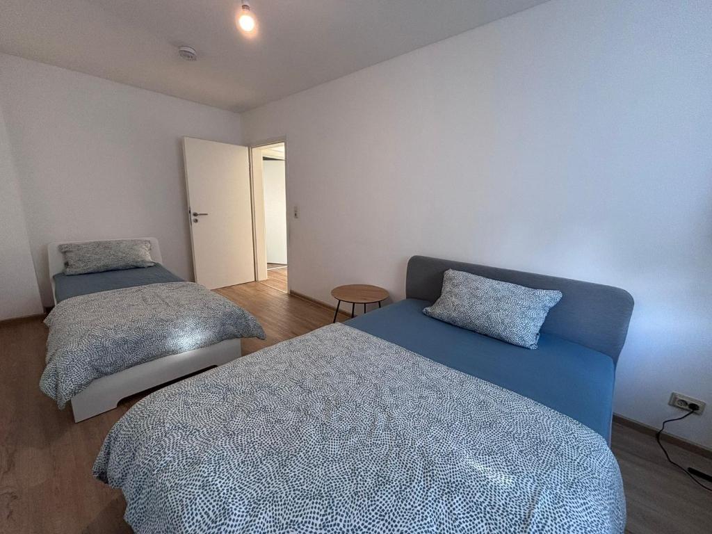 a bedroom with two beds and a blue couch at Spacious Flat with 3 bedooms for 5-8 guests in Zeitz