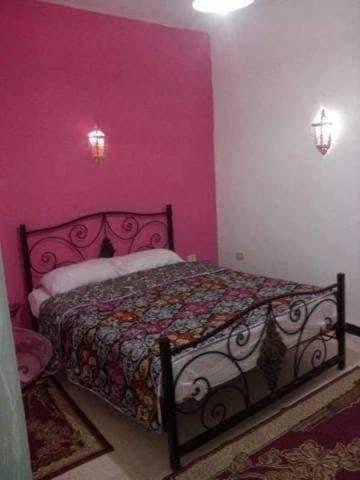 a bedroom with a bed in a pink room at Dar Karim in Midoun