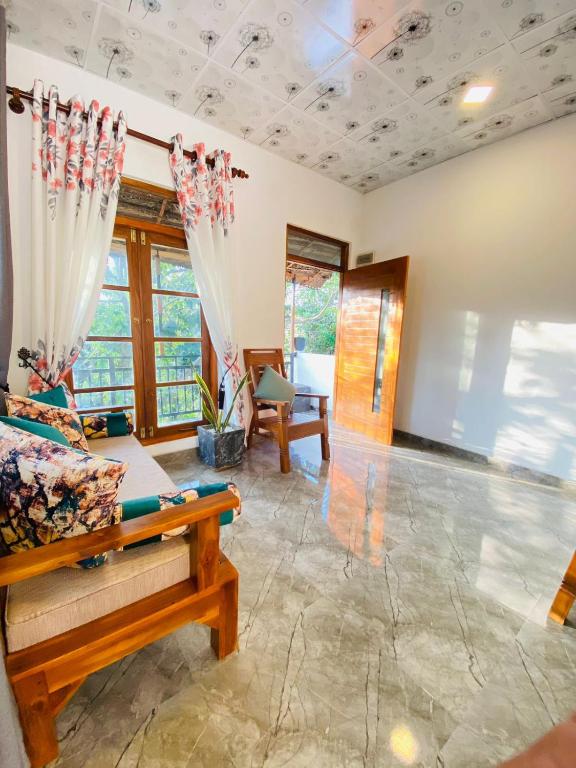 a living room with a couch and some windows at m&s villa in Weligama