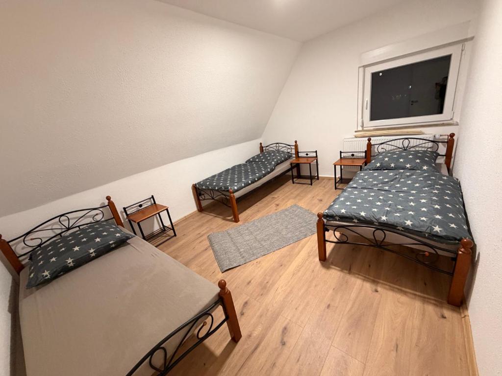 a room with three beds and a window at Workhome A2 zu 6 in Lünen