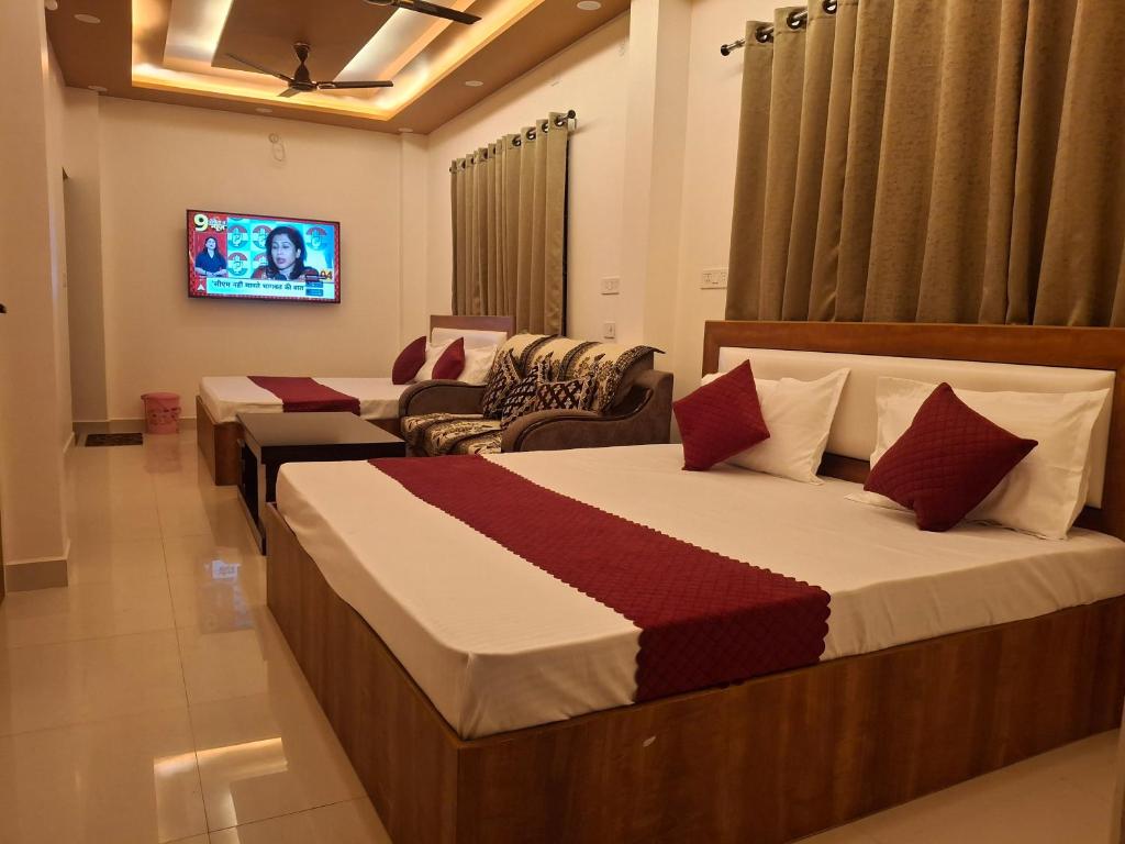 a hotel room with two beds and a flat screen tv at Vamika Palace in Ayodhya