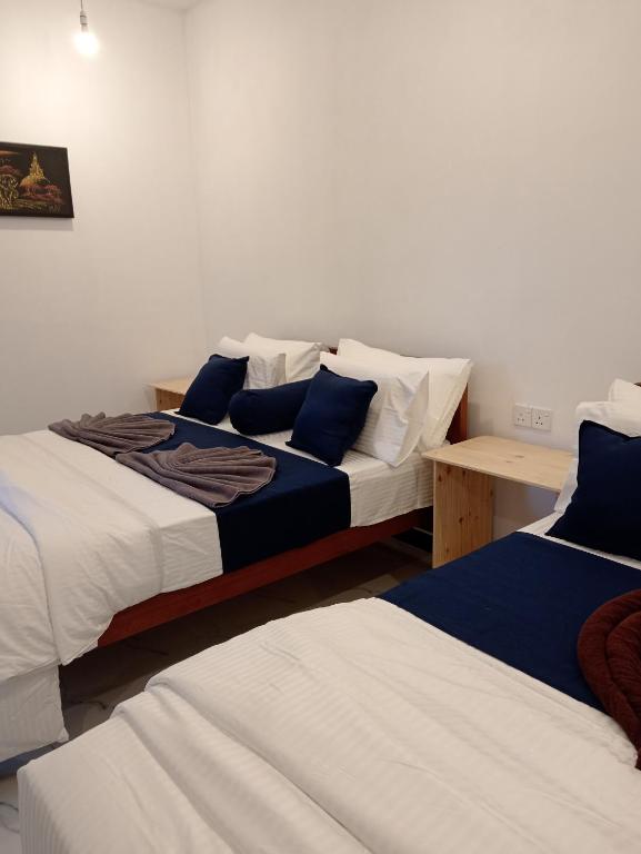 a room with two beds and a table at Camellia Guest Inn in Ella