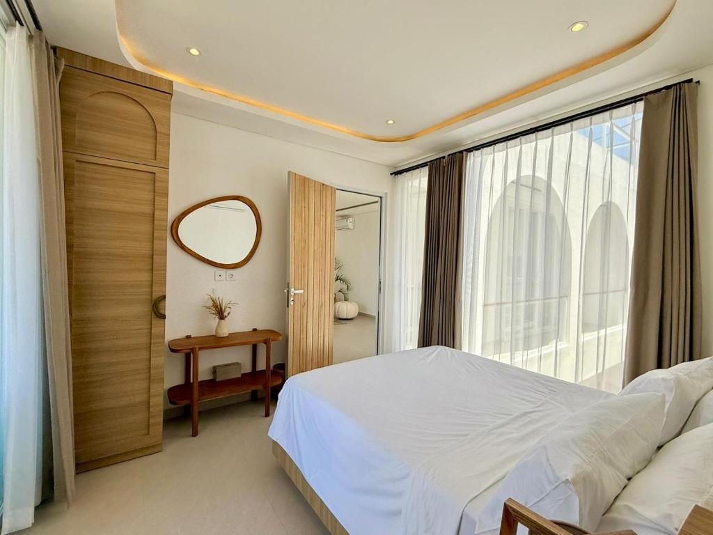 a bedroom with a large bed and a mirror at Villa Lipa in Ungasan