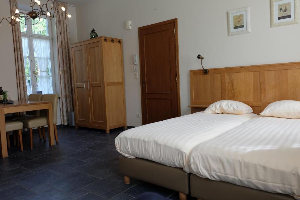 a bedroom with a bed and a desk and a table at Nice studio in 16th century castle in Aywaille