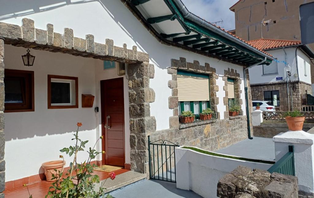 una casa bianca con un cancello e una porta di El Rincón de Silvia a Villaviciosa
