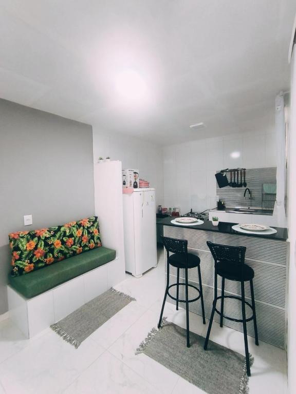 a kitchen with two chairs and a counter with a refrigerator at Bella Morena 3 - Ilha de Boipeba in Cairu