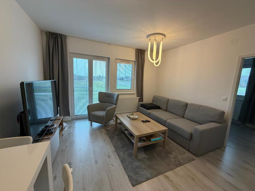 a living room with a couch and a tv at Oáza Living Mohelnice in Mohelnice
