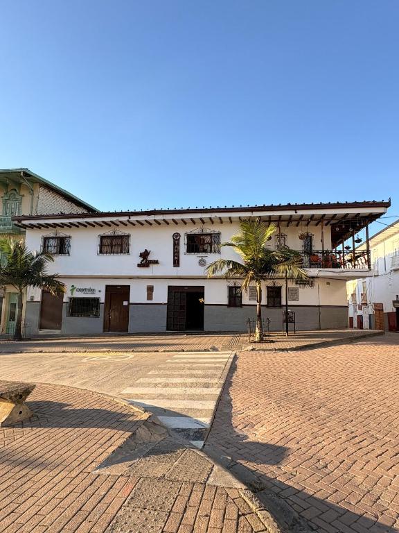 ein großes weißes Gebäude mit einer Palme davor in der Unterkunft Hotel Tahami in Sonsón